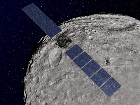 This artist's concept shows NASA's Dawn spacecraft orbiting the giant asteroid Vesta. The depiction of Vesta is based on images obtained by Dawn's framing cameras. (Image credit: NASA/JPL-Caltech)