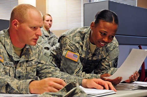 Staff Sgt. Nikishe A. Simon, the human resource non-commissioned officer-in-charge assigned to 1st Battalion, 506th Infantry Regiment, 4th Brigade Combat Team, 101st Airborne Division, and native of Brooklyn, NY, assists a soldier as part of her duties in her new assignment within a maneuver battalion at Fort Campbell, Ky. (U.S. Army photo by Spc. Thomas Christiansen, 1st Battalion, 506th Infantry Regiment, 4th Brigade Combat Team)