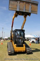 A boy drives a loader under the supervision of a driver from the Clarksville Street Department 