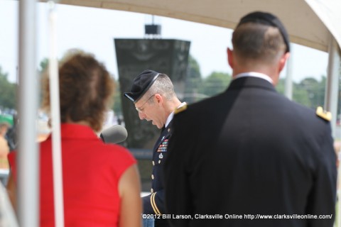 Chaplain Paul Hurley gives the invocation as Maj. Gen. James C. McConnell and his wife looks on