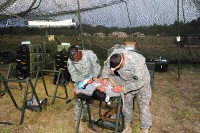 U.S. Army Staff Sgt. Nicholas A. Reasons and Spc. Veronica L. Baldwin, medics from Company C, 801st Brigade Support Battalion, 4th Brigade Combat Team, 101st Airborne Division, treat and stabilize a simulated patient during a mass casualty training exercise June 20th, 2012 at Fort Campbell, KY. (Photo by Staff Sgt. Todd Christopherson)