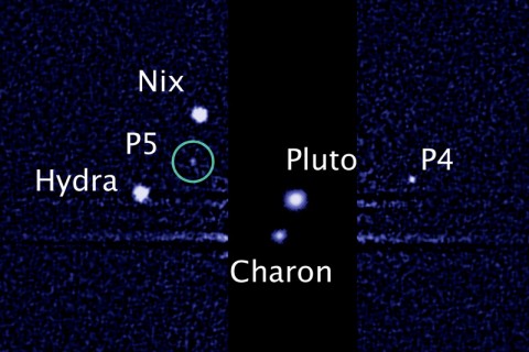 This image, taken by NASA's Hubble Space Telescope, shows five moons orbiting the distant, icy dwarf planet Pluto. The green circle marks the newly discovered moon, designated P5, as photographed by Hubble's Wide Field Camera 3 on July 7th. P4 was uncovered in Hubble imagery in 2011. (Credit: NASA; ESA; M. Showalter, SETI Institute)