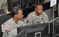 IMaj. Julia Harvey and Chief Warrant Officer 4 Dominic Goldsmith, both with the III Corps Engineer Office, review activity from their work station in the corps’ tactical operations center at Fort Hood, Texas, June 15th, 2012. The pair of two of more than 5,500 service members taking part in the III Corps Warfighter Exercise, expected to conclude June 22nd. (Photo Credit: Dave Larsen, III Corps Public Affairs)