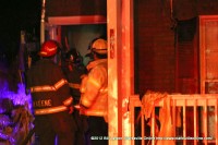 Firefighters making entry into the remains of the home