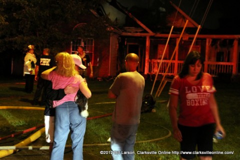 Jeff and Kathy Sale (left) comfort each other in front of their burned out home