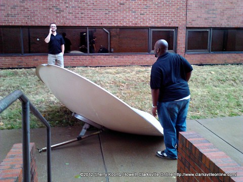 Christian Hodge (front) and Joe Mendes (rear) inspect the satellite dish blown off the Music and Mass Communication Building in yesterday's Storm. They are Graduate Assistants in the Communication Department. Christian Hodge (front) and Joe Mendes (rear) inspect the satellite dish blown off the Music and Mass Communication Building in yesterday's Storm. They are Graduate Assistants in the Communication Department.