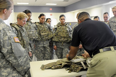 The Female Engagement Team from the 1st Brigade Combat Team, 101st Airborne Division, gather as an instructor explains how to use the Generation III Improved Outer Tactical Vest August 21st at the PPC here. (Photo by Spc. Kadina Baldwin)