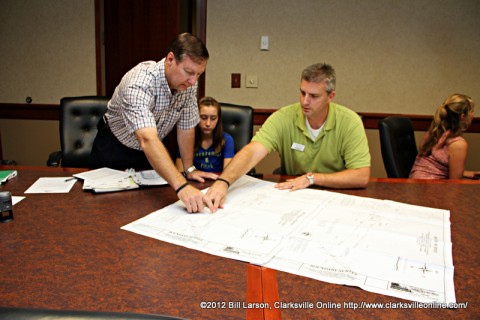 J. Lee Powell and Jon Vaughn of Better Homes and Garden Hometown Connection Real Estate look at maps showing the location of the property he donated.