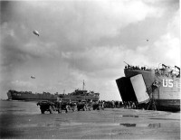 Tanks unloading from an LST, LST 325 is in the background