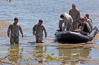 A Special Forces Operational Detachment A from 5th Special Forces Group (Airborne) dismounts a zodiac boat after they parachuted into water marking the beginning of a two-day competition. The Green Berets totaled more than 40 miles beneath their feet with a minimum of 50 pounds on their backs. (Photo by Pfc. Seth Plagenza)