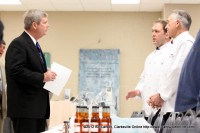 Agriculture Secretary Tom Vilsack visits with Gary and Chad Collier of Papa C Pies