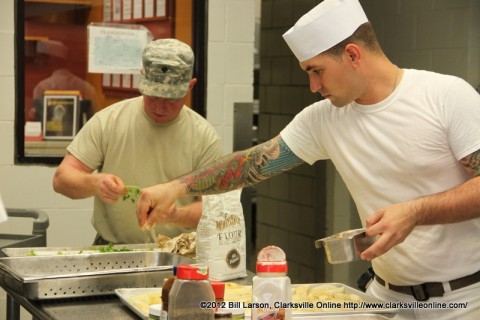 A chef seasons the food as it is prepared