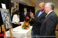 Austin Peay State University president Tim Hall showing Wes Moore the painting by Dennis Roman which took first place in the essay and creative expressions contest.