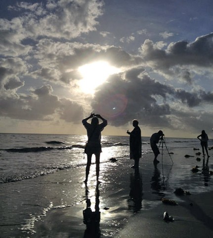 The eclipsed sun beams through clouds over Queensland Australia on Nov. 14, 2012. Note the crescent shape of the internal reflection just above the photographer's right elbow. (Photo credit: Tony Phillips)