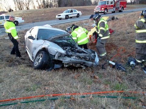 EMS works on getting the driver of a 1999 Ford Mustang out of his car. (Photo by CPD-Chris Robinson)