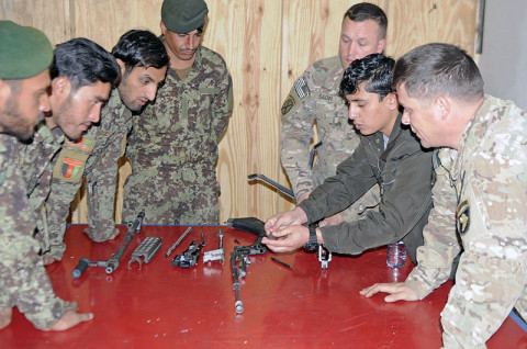 Afghan National Army soldiers from the 61st Kandak gather closely to view the different parts of an M240B machine this week on Combat Outpost Honikar-Miracle, Afghanistan. The instructors from Security Force Assistance Advisory Team 6, 2nd Battalion, 327th Infantry Regiment, 1st Brigade Combat Team, 101st Airborne Division used an interpreter to help explain the class and the names of each part. (U.S. Army photo by Sgt. Jon Heinrich, Task Force 1-101 PAO)