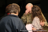 A “Strike” soldier cries even as he smiles moments after being reunited with his family