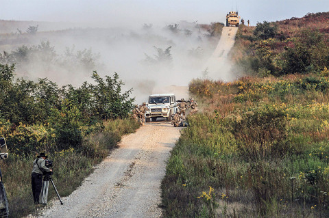 Soldiers from the 2nd Battalion, 502nd Infantry Regiment, 2nd Brigade Combat Team, 101st Airborne Division (Air Assault), capture Tanner Foust, stunt driver and Top Gear show host, during a "cat and mouse" chase scene while filming an episode for the History Channel show at a Fort Campbell training area, Sept. 26th. The week long production combined Hollywood magic with the military might of the 101st Airborne Division (Air Assault), as the Screaming Eagle Soldiers from the Strike Brigade, 2nd BCT and the 159th Combat Aviation Brigade became part of the show’s cast. (U.S. Army photo by Sgt. Joe Padula, 2nd BCT PAO, 101st Abn. Div.)