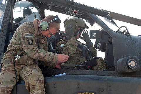 Spc. Marshall Miller, A Company, 1st Battalion, 101st Combat Aviation Brigade, AH-64 Apache helicopter crew chief, enters communication data into the systems of an AH-64 Apache helicopter during pre-flight checks at Forward Operating Base Salerno, Afghanistan, Jan. 16, 2013. (U.S. Army photo by Sgt. Duncan Brennan, 101st CAB public affairs)