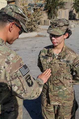 U.S. Army Sgt. Lizeth Wakasa, a food service specialist assigned to Headquarters Company, 3rd Battalion, 187th Infantry Regiment, 3rd Brigade Combat Team “Rakkasans,” 101st Airborne Division (Air Assault), is promoted to sergeant by her husband U.S. Army Spc. David Wakasa, also a food service specialist with Headquarters, 3-187, at Combat Outpost Bowri Tana, Dec. 1st, 2012. (U.S. Army photo by Sgt. 1st Class Abram Pinnington, Task Force 3/101 Public Affairs)