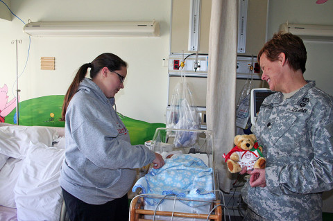 Blanchfield Army Community Hospital Assistant Deputy Nurse Lt. Col. Sandra McNaughton makes an early Valentine Bear delivery February 1st to 11-day-old Walker Burkepile. Walker's mother, Stacey Burkepile, is staying in the hospital with Walker until he is well enough to go home. Twenty bears were donated by the Fort Campbell Better Opportunities Soldiers for BACH staff to hand out to patients during Patient Recognition Month.