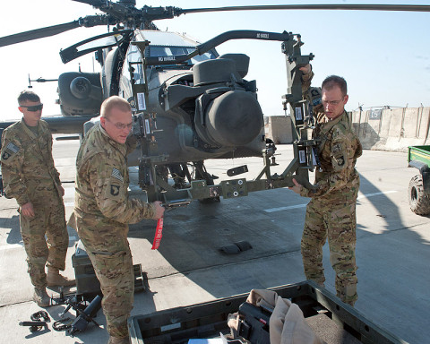 Sgt. Lee Denhe (right) and Pfc. Keith Recore (left), D Company, 1st Battalion, 101st Combat Aviation Brigade avionics and weapons systems technicians, take a sighting kit off of an AH-64D Apache helicopter after conducting maintenance at Forward Operating Base Salerno, Afghanistan, Jan. 23, 2013. (U.S. Army photo by Sgt. Duncan Brennan, 101st CAB public affairs)