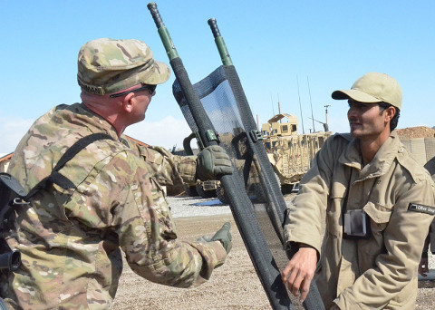 U.S. Army Pfc. Joshua Greenman, a combat medic with Headquarters and Headquarters Battery, 3rd Battalion, 320th Field Artillery Regiment, 101st Airborne Division (Air Assault), helps an Afghan security guard setup a litter for a practical exercise as part of a first-responder medical training exercise held at Forward Operating Base Lightning, Feb. 19, 2013.  (U.S. Army photo illustration by Spc. Tianna Waite, 115th Mobile Public Affairs Detachment)