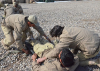 Afghan security guards participate in a litter carry exercise as part of a first-responder training course held on Forward Operating Base Lightning, Feb. 19, 2013. The training, led by coalition forces teaches Afghans the essentials in treating wounded personnel on the base. Badges have been blurred for security reasons. (U.S. Army photo illustration by Spc. Tianna Waite, 115th Mobile Public Affairs Detachment)