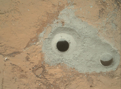 At the center of this image from NASA's Curiosity rover is the hole in a rock called "John Klein" where the rover conducted its first sample drilling on Mars. The drilling took place on Feb. 8th, 2013, or Sol 182, Curiosity's 182nd Martian day of operations. Several preparatory activities with the drill preceded this operation, including a test that produced the shallower hole on the right two days earlier, but the deeper hole resulted from the first use of the drill for rock sample collection. (Image credit: NASA/JPL-Caltech/MSSS)