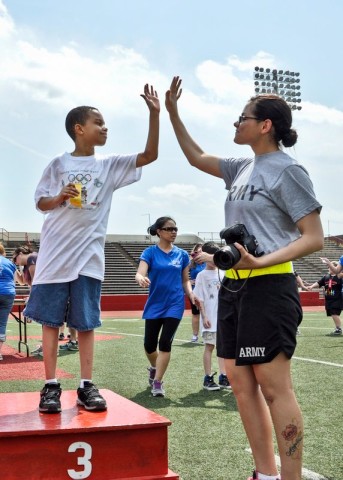 Spc. Angela Tedeski, a medic with Company C, 526th Brigade Support Battalion, 2nd Brigade Combat Team, 101st Airborne Division (Air Assault), congratulates students from Fort Campbell’s Barsanti Elementary School as they receive their placement ribbons during the Area 12 Special Olympics, held at Clarksville’s Austin Peay Stadium on April 18. (US Army photo by Sgt. Keith Rogers, 2nd BCT UPAR, 101st Abn. Div.)