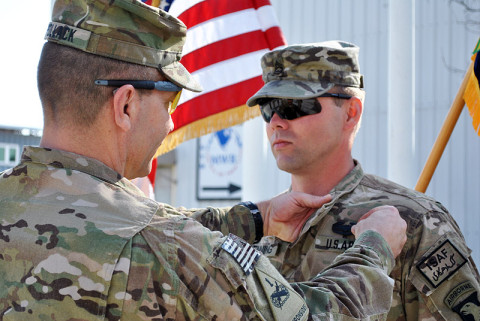 U.S. Army Sgt. Maj. Thomas M. Pollack, a Pembine, WI, native, pins the Combat Action Badge on his son, U.S. Army Sgt. 1st Class Raymond J. Benning, during a ceremony March 29, 2013. (U.S. Army photo by Sgt. Zila Winstead, RC-East Public Affairs)