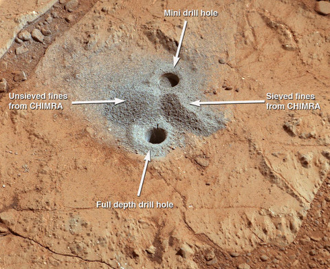 This image shows the first holes into rock drilled by NASA's Mars rover Curiosity, with drill tailings around the holes plus piles of powdered rock collected from the deeper hole and later discarded after other portions of the sample had been delivered to analytical instruments inside the rover. (NASA/JPL-Caltech/MSSS)