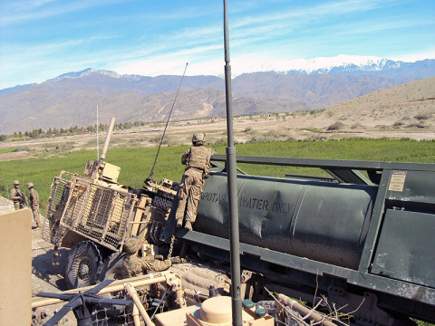 U.S. Army Spc. Peter Brousseau, a member of the Forward Operating Base Fenty Quick Reaction Force and the 426th Brigade Support Battalion, 1st Brigade Combat Team, 101st Airborne Division, attaches an anchor weight in order to prevent a water supply tank from rolling over. (U.S. Army photo by 1st Lt. Lisa Maginot, 426th BSB Unit Public Affairs Representative)