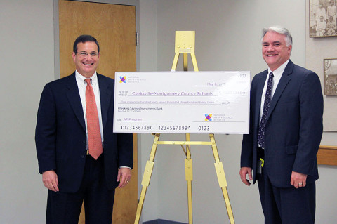 Schools Director B.J. Worthington accepts a $1.6 million grant from Gregg Fleisher, chief program officer for the National Math and Science Initiative.