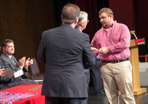 APSU President Tim Hall presents graduate and veteran Darrell Sheffield with an APSU military coin. (Photo by Beth Liggett/APSU).