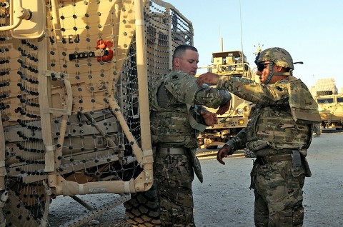 U.S. Army Sgt. Osbaldo Espinoza, right, a platoon team leader, and Spc. Dustin J. Johnson, motor transport operator, both with the 3rd Platoon, 1245th Transportation Company, 1034th Combat Sustainment Support Battalion, assist each other with straps on their improved outer tactical vest as they prepare for their convoy escort team mission at Mazar-e-Sharif, Balkh province, Afghanistan, June 18, 2013. (U.S. Army photo by Sgt. Sinthia Rosario/Released)