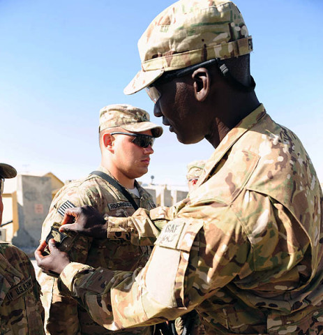 U.S. Army 1st Sgt. Amara Fofana, 1st Sgt., Forward Operating Base Lightning Garrison Support Unit, 4th Battalion, 320th Field Artillery Regiment, 4th Brigade Combat Team “Currahee”, 101st Airborne Division (Air Assault) presents Pfc. Kevin Rodriguez, with the 101st Airborne Division combat patch. (U.S. Army National Guard photo by Spc. Ryan Scott, 129th Mobile Public Affairs Detachment)