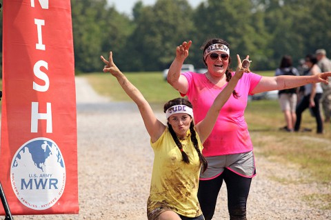 Two ladies take a second to pose for a photo at the finish line of the Special Operations Forces Warrior Challenge hosted by the 5th Special Forces Group (Airborne) and the 160th Special Operations Aviation Regiment (Airborne) on June 8th, at Fort Campbell, Ky. (Photo By: Spec. Seth Plagenza)