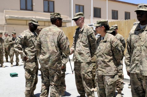 Commander of Task Force Lifeliner, Col. Charles R. Hamilton a native of Houston, Texas, gives a coin to Staff Sgt. Aaron S. Manis a native of Huntington, W.Va., with Task Force Lifeliner during a reenlistment ceremony at Bagram Airfield in Parwan, Afghanistan, July 4, 2013. This is the first reenlistment TF Lifeliner has conducted since arriving down range. (Sgt. Sinthia Rosario/U.S. Army)