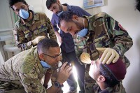 U.S. Capt. Abby Raymond, a brigade dentist with the 4th Brigade Combat Team, 101st Airborne Division (Air Assault), checks the work of an Afghan medic with the 2nd Commando Battalion, 203rd Corps, Afghan National Army, performing an oral exam on a fellow commando during a basic dental class at Forward Operating Base Thunder in Paktia province, Afghanistan, July 22, 2013. (U.S. Army photo by Sgt. Justin A. Moeller/Released)