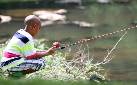 Camper Apollo Kim, 8, enjoys a peaceful moment fishing July 10th, at Fort Campbell, KY. The goal of the Fort Campbell Survivors Outreach Services Camp SOS is for the children to have a week of fun. (U.S. Army photo by Sgt. Leejay Lockhart, 101st Sustainment Brigade Public Affairs)