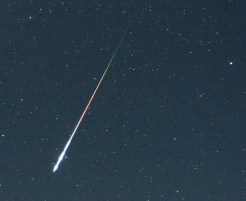 Larger meteoroids cause bright flashes of light when they hit Earth's atmosphere, such as this fireball caught during the Perseid meteor shower Aug. 12, 2006. The bulk of meteoric activity is much less showy: Some 10 to 40 tons of meteor dust enter our atmosphere every day. (Image Credit: Courtesy of Pierre Martin)