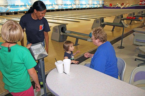 Sgt. 1st Class Takethia Branch, a retention non commissioned officer assigned to Headquarters, Headquarters Company, 3rd Brigade Combat Team "Rakkasans," 101st Airborne Division (Air Assault), celebrates with a table of young athletes with the Buddy Ball program at the Pinnacle bowling alley, Clarksville, Tenn., Aug. 27, 2013. (Army Photo by Spc. Brian Smith-Dutton, 3BCT Public Affairs)