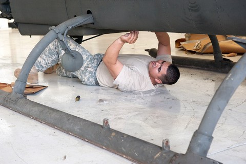 Spc. Abraham Feria, B Company, 96th Aviation Support Battalion, 101st Airborne Division (Air Assault), OH-58D electronics, avionics and armament technician, installs rivets into the undercarriage of an AH-1F Cobra helicopter in the final stages of restoration at Fort Campbell, Ky., Aug. 19, 2013. (U.S. Army photo by Sgt. Duncan Brennan, 101st CAB Public Affairs)