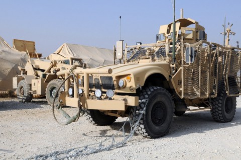 Pfc. Val J. Irick (left), a native of Daytona Beach, Fla., and Pfc. Ryan M. Sindle (right), a native of Elkhart, Ind., both soldiers with the Task Force Lifeliner command security team, attach firmly a snow chain on a mine resistant ambushed protected vehicle tire as part of winter training class, Oct. 26, 2013, at Bagram Air Field, Parwan province, Afghanistan. This training teaches the soldiers how to properly apply snow chains on tires and how to operate their vehicles in cold weather conditions. (Sgt. Sinthia Rosario, Task Force Lifeliner Public Affairs)