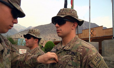 Second Lt. Karl F. Knowlton, air mobility deputy with Task Force Lifeliner, prepares to strip the specialist rank off the uniform of newly promoted Sgt. George C. Knowlton, a team leader with 3rd Squadron, 89th Cavalry, 4th Infantry Brigade Combat Team, 10th Mountain Division, during a promotion ceremony, at Forward Operating Base Wright, Kunar province, Afghanistan. Both brothers are from Winder, GA. (U.S. Army photo by Staff Sgt. Peter R. Sinclair, Task Force Lifeliner Public Affairs)