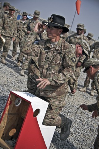 U.S. Army Lt. Col. Thomas T. Sutton, commander of 1st Squadron, 61st Cavalry Regiment, 4th Brigade Combat Team, 101st Airborne Division (Air Assault), kneels on a platform as gold spurs are put on his boots, during a spur ceremony at Camp Clark, Afghanistan, Oct. 11, 2013. (U.S. Army photo by Sgt. Justin A. Moeller, 4th Brigade Combat Team Public Affairs)