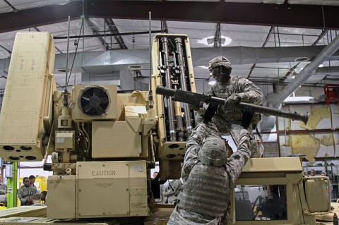 Spc. Kendal Smithson, an Avenger team chief from Battery C, 2nd Battalion, 44th Air Defense Artillery, 101st Sustainment Brigade, 101st Airborne Division (Air Assault), passes a Stinger missile simulator to Spc. Coree Duboise, an Avenger crew member also from Battery C, during timed and graded crew drill event Oct. 2, at Fort Campbell, Ky. The event was part of a competition to determine the best Stinger missile team in the battalion. (U.S. Army photo by Sgt. Leejay Lockhart, 101st Sustainment Brigade Public Affairs)