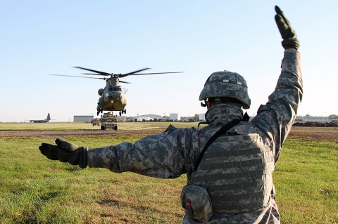 Spc. Dillon Cihak, a Sentinel crew member with Battery C, 2nd Battalion, 44th Air Defense Artillery, 101st Sustainment Brigade, 101st Airborne Division (Air Assault), uses hand and arm signals to guide a Ch-47 Chinook helicopter during a sling load operation Oct. 22 at Fort Campbell, Ky. (U.S. Army Photo by Sgt. Leejay Lockhart, 101st Sustainment Brigade Public Affairs)