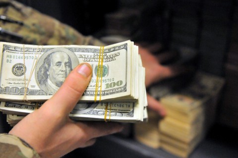 A soldier deposits funds into a safe in a finance office, at Bagram Air Field, Parwan province, Afghanistan. The 101st Financial Management Support Detachment, effectively manages millions of dollars throughout Afghanistan. The 101st Financial Management Support Detachment is a Massachusetts National Guard Unit. (Sgt. Sinthia Rosario/U.S. Army)